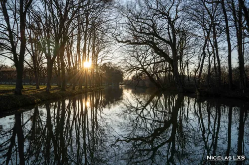 Canal du parc de la Motte-Tilly reflétant les arbres à contre-jour