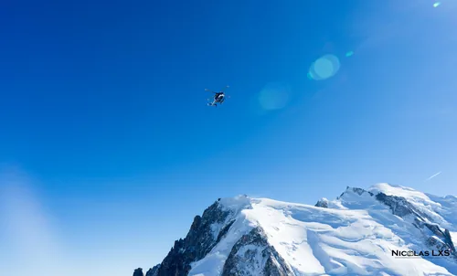 Hélicoptère au-dessus des sommets enneigés du massif du Mont-Blanc