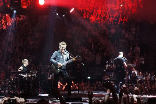 Concert de Muse : le chanteur à la guitare au premier plan